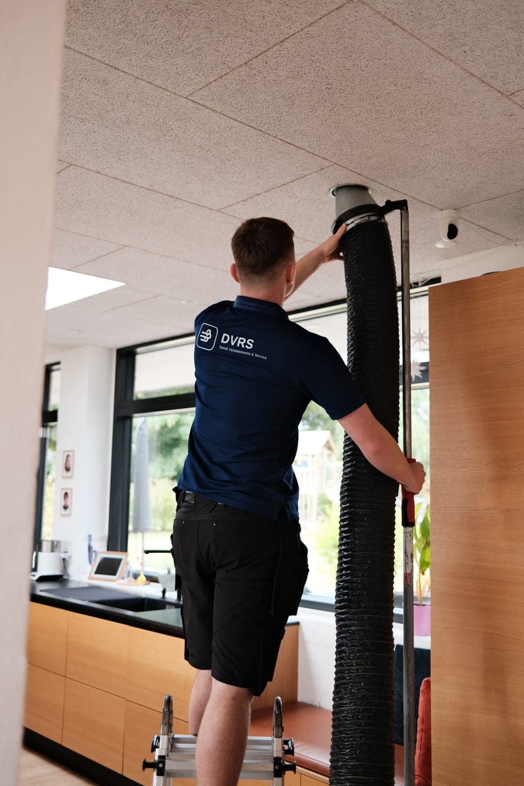 DVRS-tekniker fører renseslange ind i ventilationskanalen